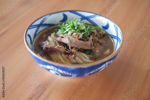 Rice noodle with beef in bowl on wooden table background. photo