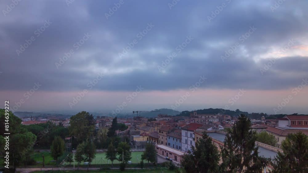 Golden Hour Charm: Albano Laziale Sunset Timelapse - Aerial View of Old Houses, Trees, and Red Roofs Amidst a Colorful Summer Evening Sky in Italy. Golden Hour Charm: Albano Laziale Sunset Timelapse - Aerial View of Old Houses, Trees, and Red Roofs Amidst a Colorful Summer Evening Sky in Italy.