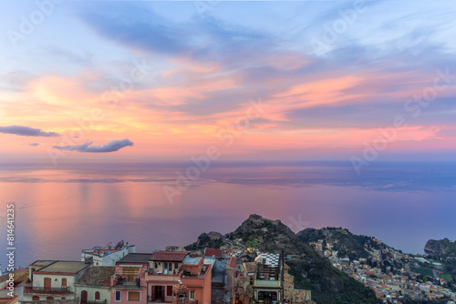 sceniv view from a high mountain town to amazing landscape of sea coast, roofs in vintage style of Italy and beautiful colorful sunset or sunrise cloudy sky © Yaroslav