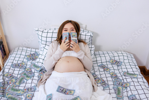 asian pregnant woman holds a lot of money in her hand. Monetary expenses for pregnancy and childbirth