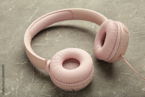 Pink modern headphones on grey concrete background