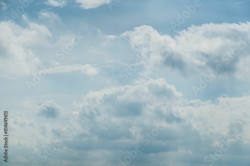 Fluffy white clouds in the pastel blue sky on a sunny day