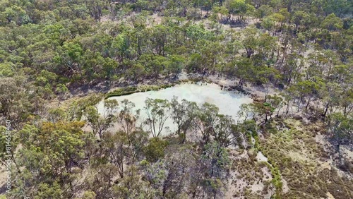 Aerial footage of small lake surrounded by green trees in the woods of Emmaville, NSW, Australia photo