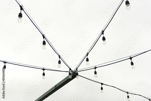Konstfotografi Black and white shot of string lights against the sky