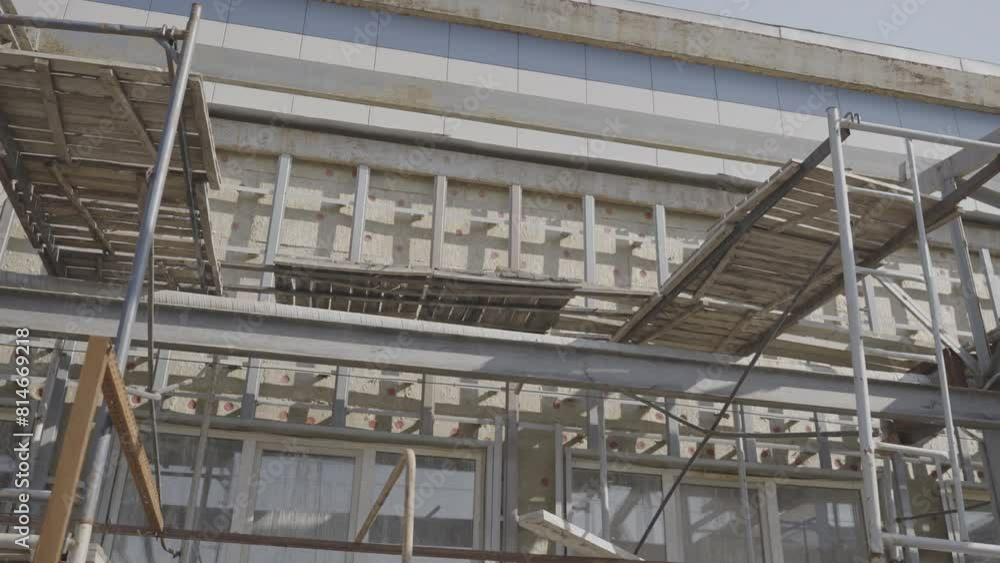 Scaffolds with wooden boards near restored building facade. Reconstruction of old house on city street. Architectural project development Scaffolds with wooden boards near restored building facade. Reconstruction of old house on city street. Architectural project development