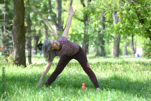 Portrait photo of happy senior Caucasian woman relaxing and breathing fresh air with sunlight in outdoors park. Elderly woman enjoying a day in the park on summer. Healthcare lifestyle and wellness