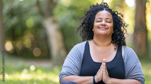 A plus-size woman practicing yoga in a serene outdoor surrounded by nature and finding inner peace and balance through mindfulness and meditation emphasizing the inclusivity of yoga for all body types