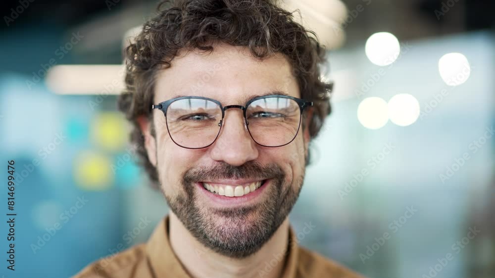 Portrait of happy bearded entrepreneur in glasses standing at the workplace in a business office. Confident successful smiling businessman looking at camera. Head shot of positive man worker. Close up Portrait of happy bearded entrepreneur in glasses standing at the workplace in a business office. Confident successful smiling businessman looking at camera. Head shot of positive man worker. Close up
