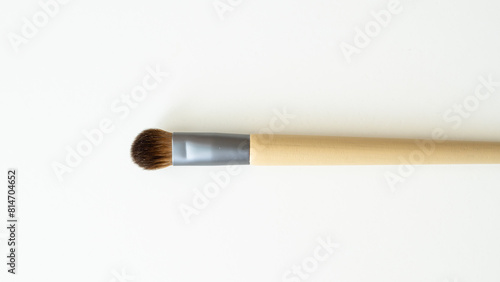 Wooden organic makeup brushes on white backdrop. Eco-friendly