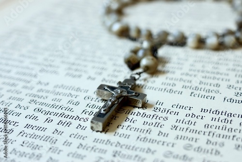Religion, Christentum, Gebet und kirchliche Feiertage symbolisiert ein Rosenkranz mit Kreuz auf einem Gebetbuch photo