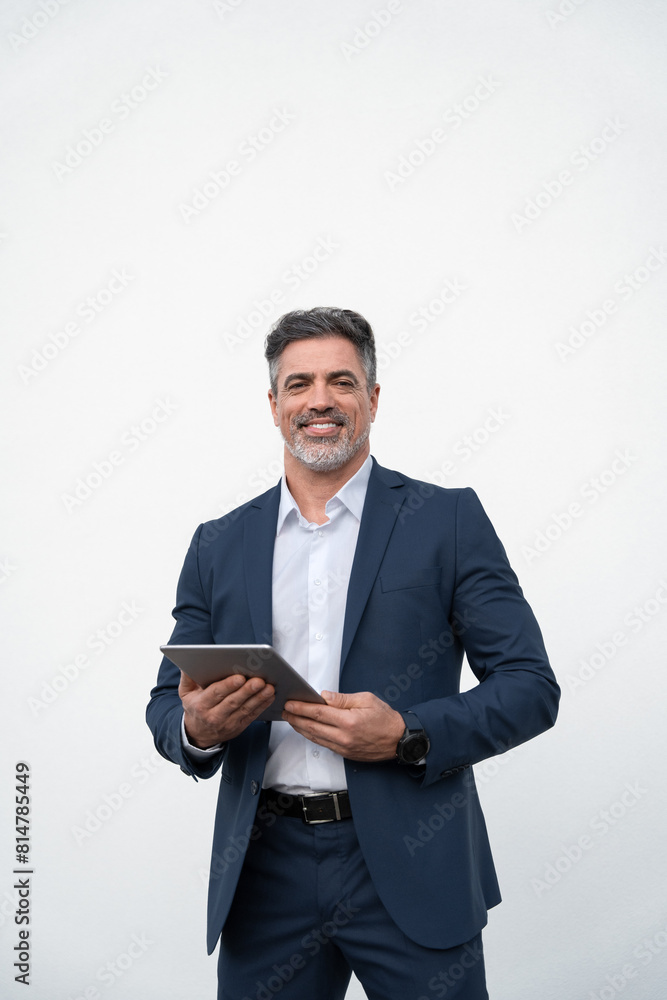 Middle age mature businessman using pc tablet for business work application. Smiling handsome older man in formal suit holding touchscreen device looking aside. Isolated white background, Vertical Middle age mature businessman using pc tablet for business work application. Smiling handsome older man in formal suit holding touchscreen device looking aside. Isolated white background, Vertical