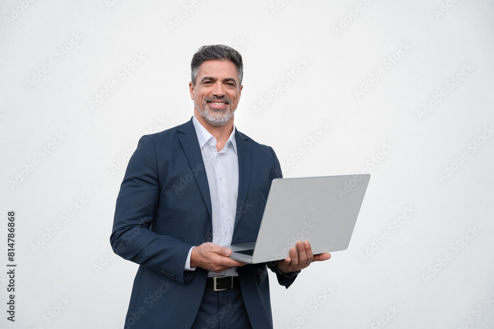 Portrait of middle age mature businessman using pc laptop for business work. Smiling handsome older man in formal suit holding desktop computer, looking at camera. Isolated white background copy space Portrait of middle age mature businessman using pc laptop for business work. Smiling handsome older man in formal suit holding desktop computer, looking at camera. Isolated white background copy space