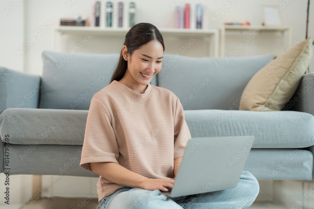 Naklejka premium Young woman working on laptop at home