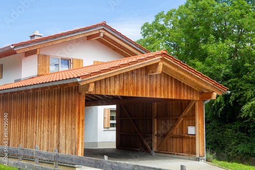 Schöner Carport aus Holz vor einem Wohnhaus in alpenländischem Stil