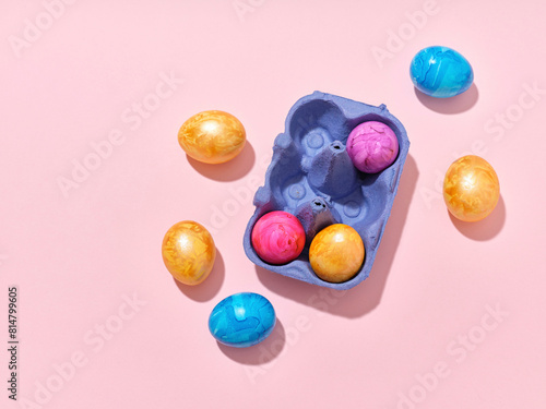 Top view layout with colored easter eggs on pink background photo