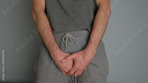 A man with prostate disease holds his hands in the groin area.