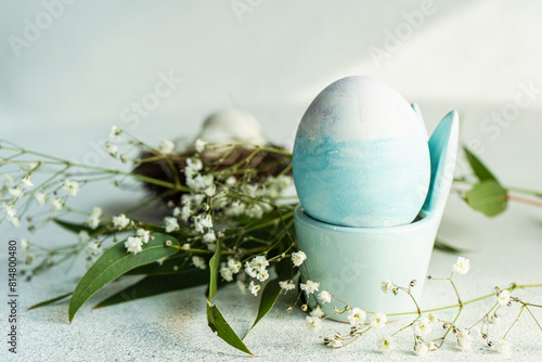 Blue colored egg in egg cup as Easter card concept photo