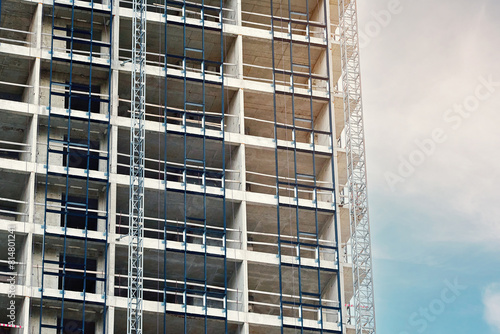 Building under construction, installing aluminum frame support for glass facade. Preparation for installation of window elements on building facade. .