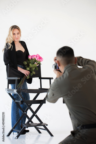 Photographer films a woman with a bouquet in the studio