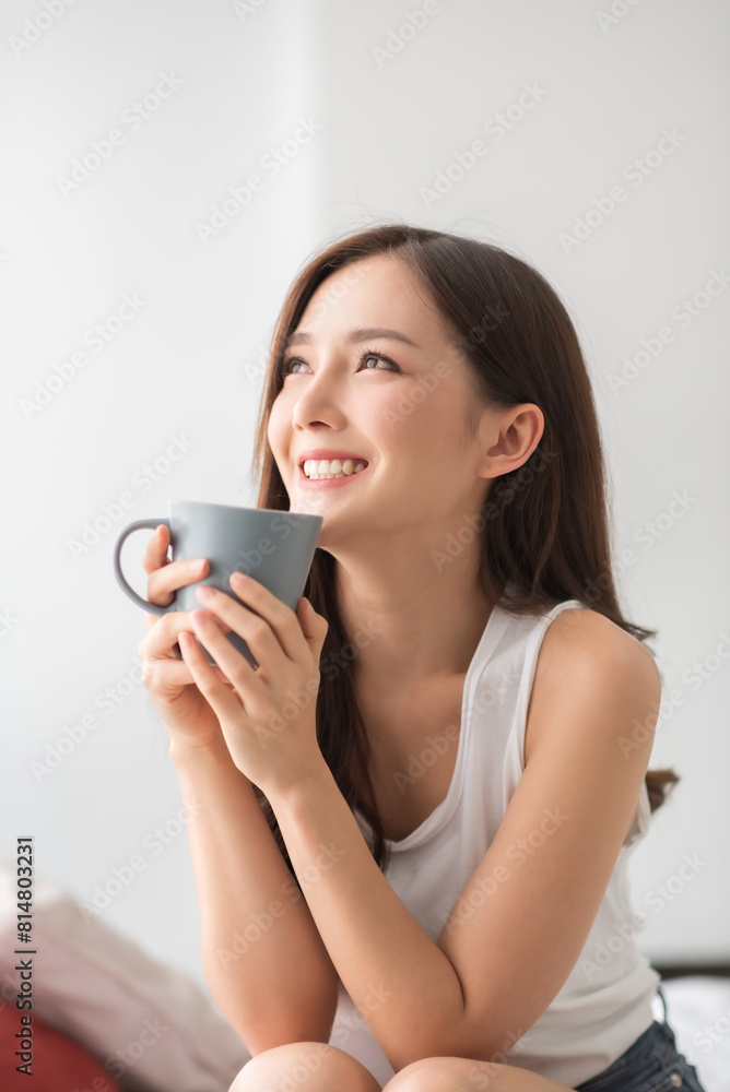 Portrait of Pretty Asian woman holding a cup of coffee relaxing enjoying at home. Lifestyle Beautiful female laughing with positive emotion. Banner. Portrait of Pretty Asian woman holding a cup of coffee relaxing enjoying at home. Lifestyle Beautiful female laughing with positive emotion. Banner.