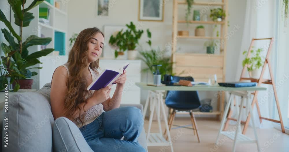 Smiling Woman Reading While Walking Sitting on Sofa at Home Smiling Woman Reading While Walking Sitting on Sofa at Home