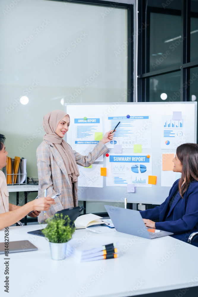A multicultural team of professionals, including male and female businesspersons, convenes around a desk with tablets, discussing strategies illustrated on a whiteboard during a dynamic presentation. A multicultural team of professionals, including male and female businesspersons, convenes around a desk with tablets, discussing strategies illustrated on a whiteboard during a dynamic presentation.