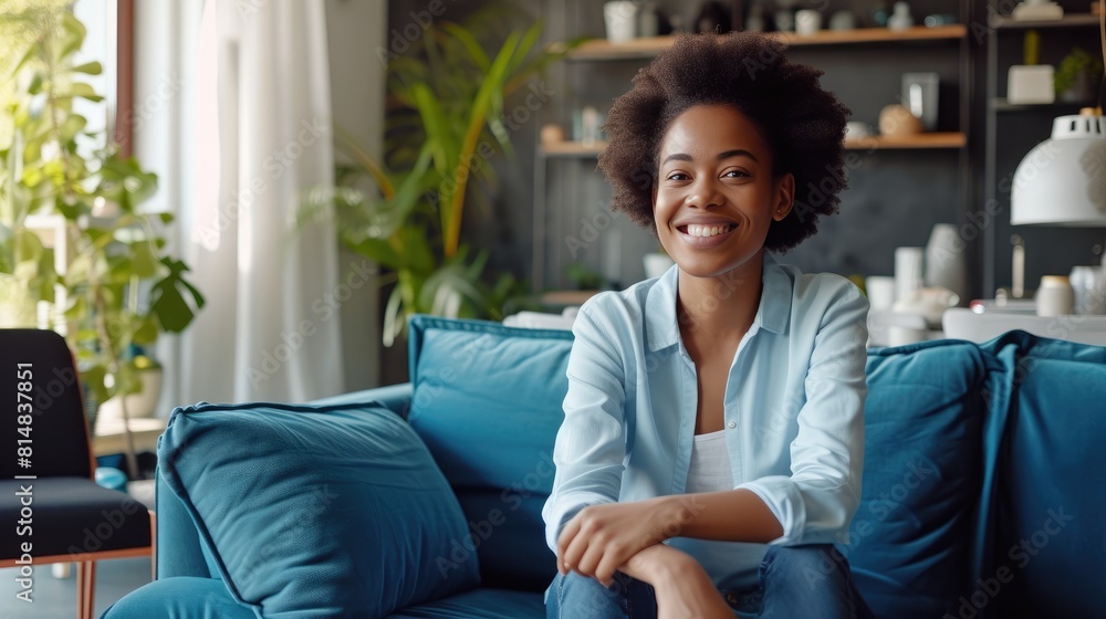 Obraz premium Casual Elegance: Smiling Woman in Business Attire on Blue Sofa