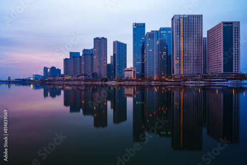 Skyscrapers reflection upon a river at dawn in Tongzhou District, Beijing, China, which is a newly-established business district