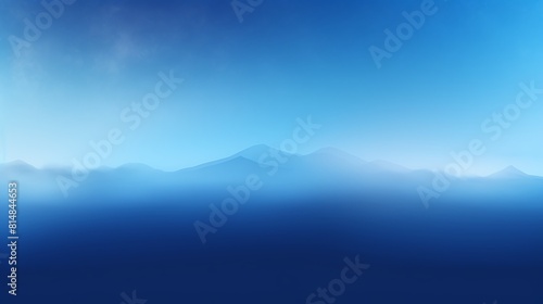 Generate a high-resolution image of a blue mountain range in the distance with a blue sky and white clouds. The mountains should be partially obscured by a blue mist.