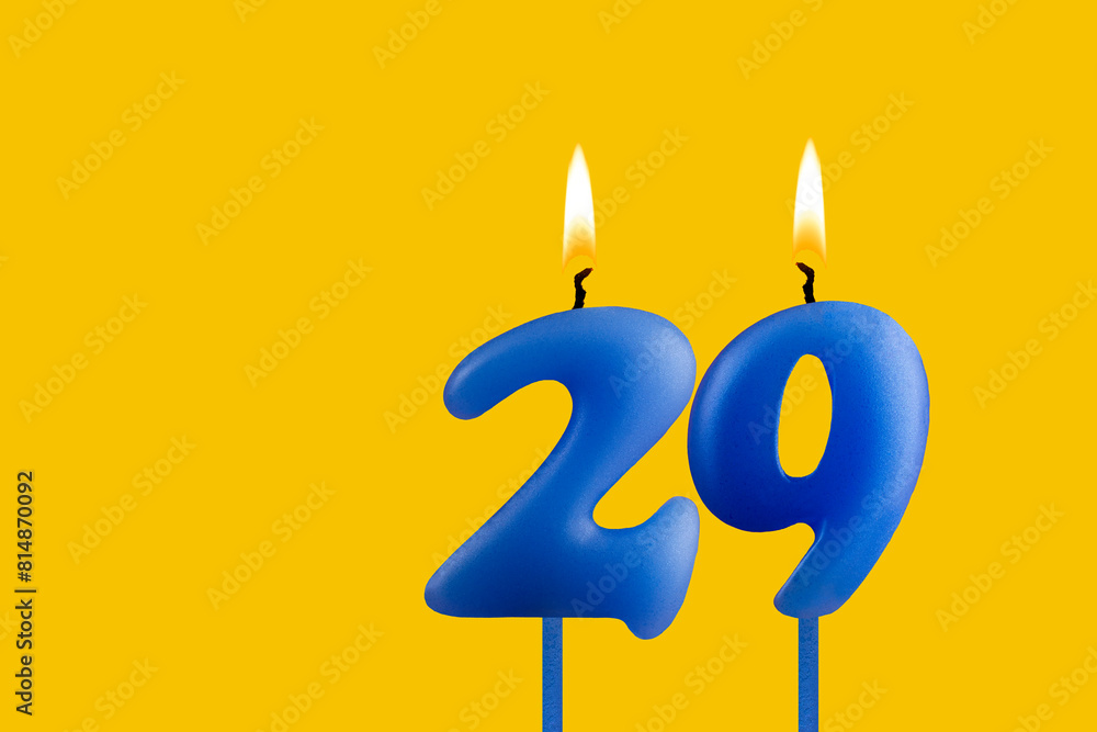 Blue candle number 29 - Birthday on yellow background Blue candle number 29 - Birthday on yellow background