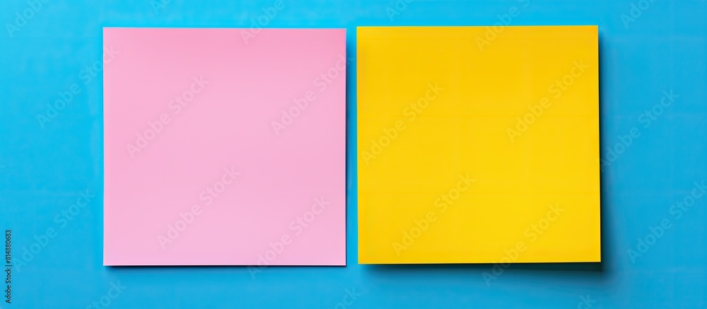 On a blue background there are two yellow and pink square paper stickers creating a frame There is blank space inside for copying On a blue background there are two yellow and pink square paper stickers creating a frame There is blank space inside for copying