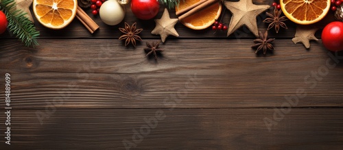 A Christmas themed flat lay featuring various festive elements such as cinnamon sticks blood orange slices anise a candy cane golden stars a white cinnamon star and a candle The setup is placed on a photo