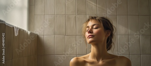 A woman with closed eyes stretches in a bathroom in the morning creating a serene and tranquil image There is ample empty space for creativity in this picture photo