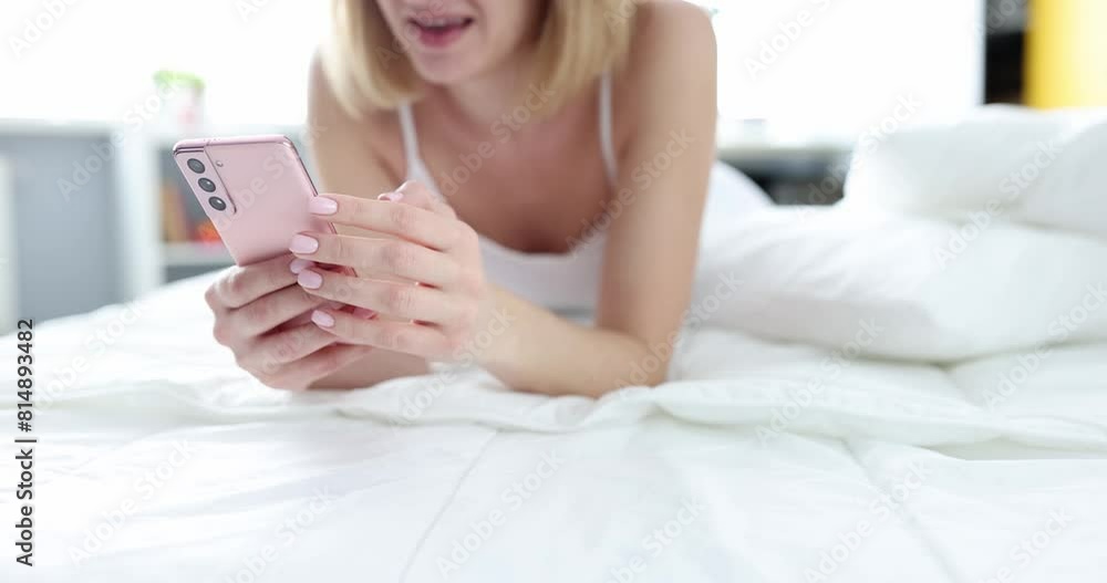 Woman is chatting on phone lying in bed. Online communication and smartphone use Woman is chatting on phone lying in bed. Online communication and smartphone use