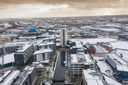 Aerial photo of the area in the Leeds City Centre known as Brewery Wharf showing snow covered apartment buildings along side the Leeds and Liverpool canal in the winter time photo