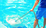 Man cleaning the pool with vacuum. Cleaning pool service