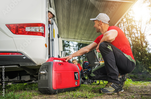 Man Operating RV Generator. Camper Van Dry Camping. © Tomasz Zajda