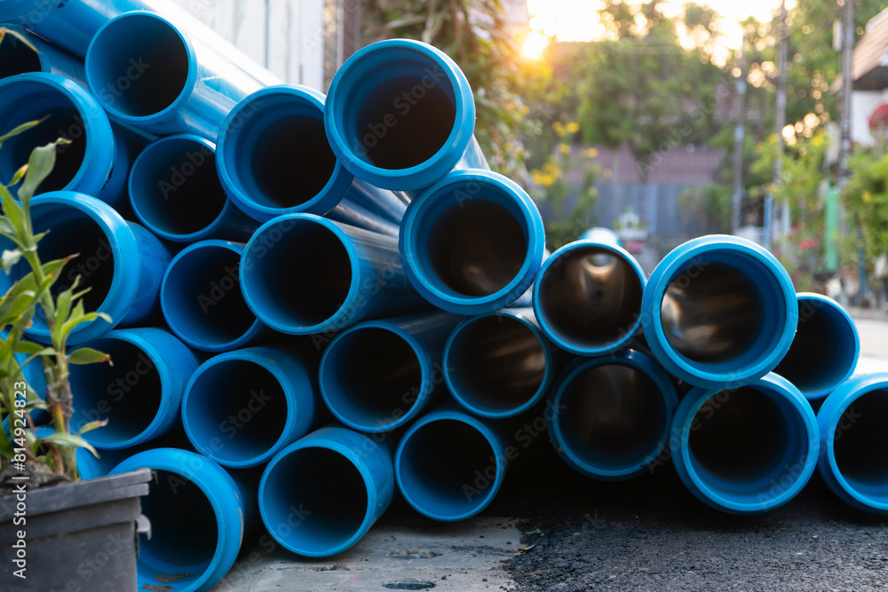 Blue plastic pipes of different diameters lie on the ground. They are used for plumbing and drainage. Blue plastic pipes of different diameters lie on the ground. They are used for plumbing and drainage.