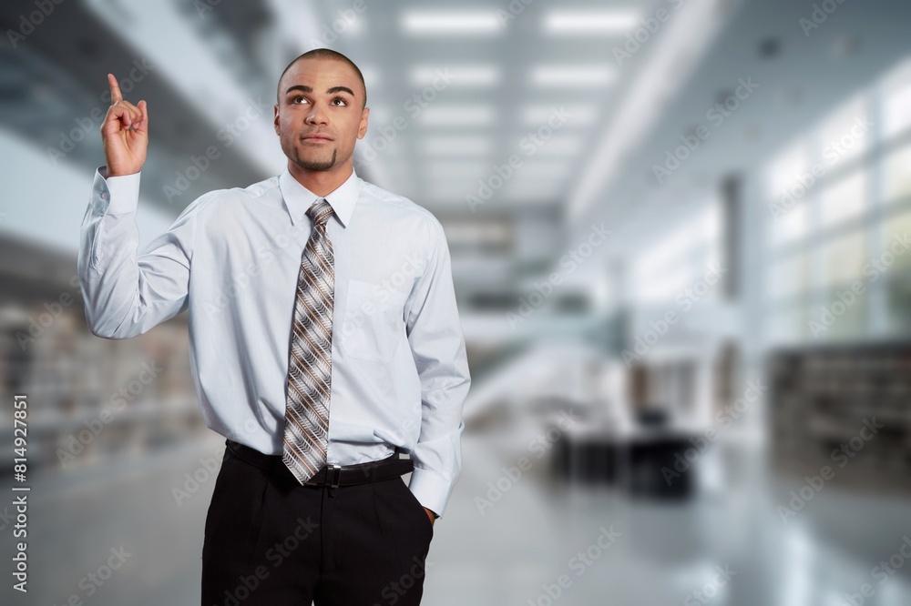 Happy businessman standing at workplace in office Happy businessman standing at workplace in office