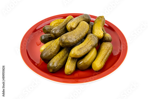 Pickled cucumbers on a red plate isolated on white