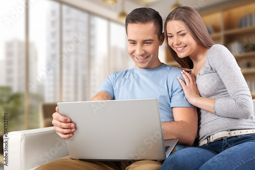 Happy young couple with laptop relaxing at home. © BillionPhotos.com