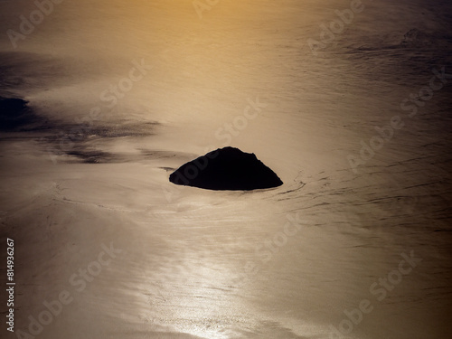 Alicudi island aerial view from airplane at golden sunset, Aeolian Islands, Sicily, Italy