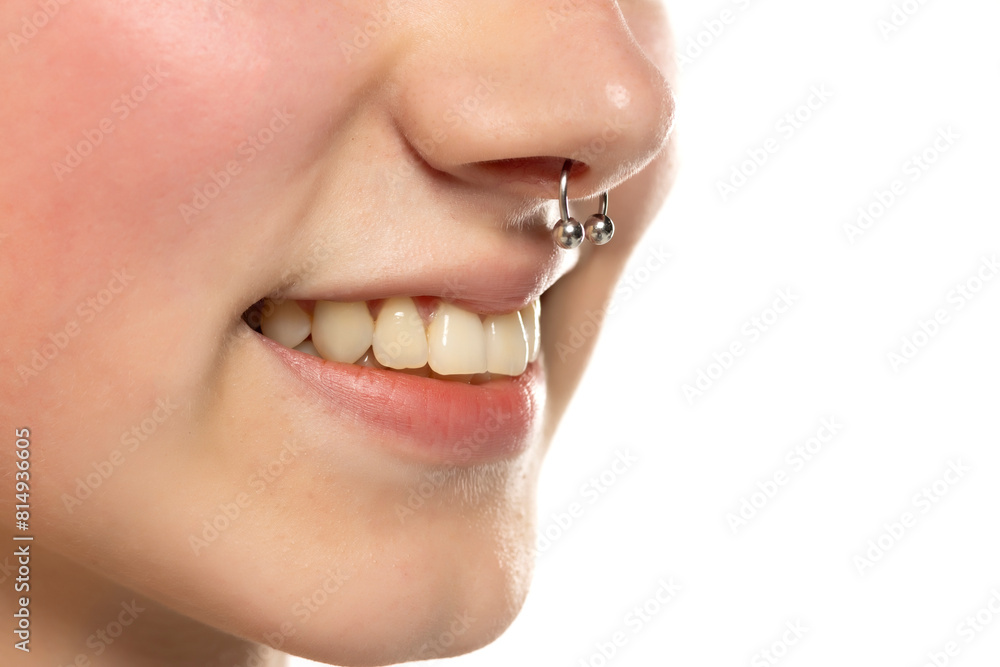 Obraz premium Closeup of a young smiling woman's visage with piercing septum hanging from her nose