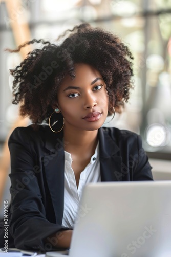 Businesswoman sitting at desk in office using laptop