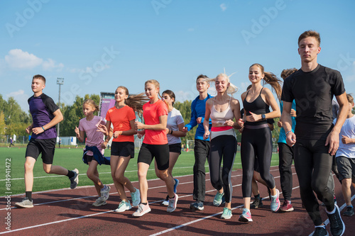 Group of young athletes training at the stadium. School gym trainings or athletics photo
