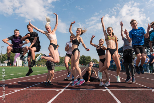 Group of young athletes training at the stadium. School gym trainings or athletics photo