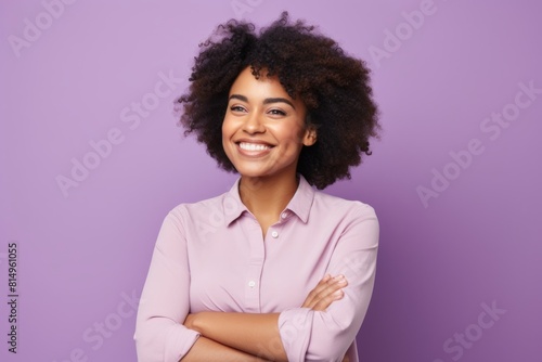 Portrait of a cheerful afro-american woman in her 30s with arms crossed isolated in pastel purple background
