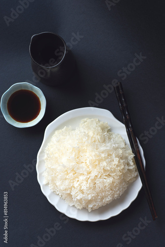 Tremella mushrooms or  white  fungus or snow fungus, are edible mushrooms  full of  antioxidant properties with soy sauce: for salads, soups Asia, Korea, China, Russia, dark background photo