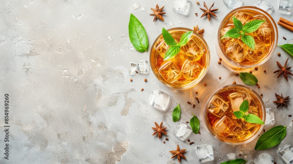 Three glasses of iced tea with mint and star anise on a pristine white surface Each glass holds a few sprigs of mint, a star anise, ice cubes, Three glasses of iced tea with mint and star anise on a pristine white surface Each glass holds a few sprigs of mint, a star anise, ice cubes,