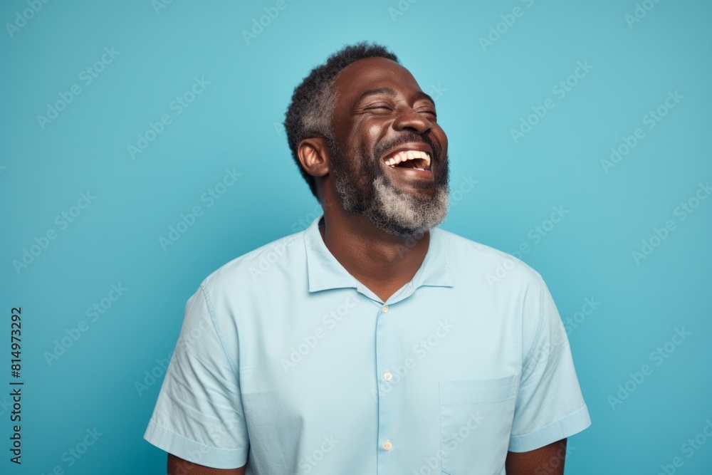 Portrait of a blissful afro-american man in his 40s laughing isolated on pastel teal background Portrait of a blissful afro-american man in his 40s laughing isolated on pastel teal background